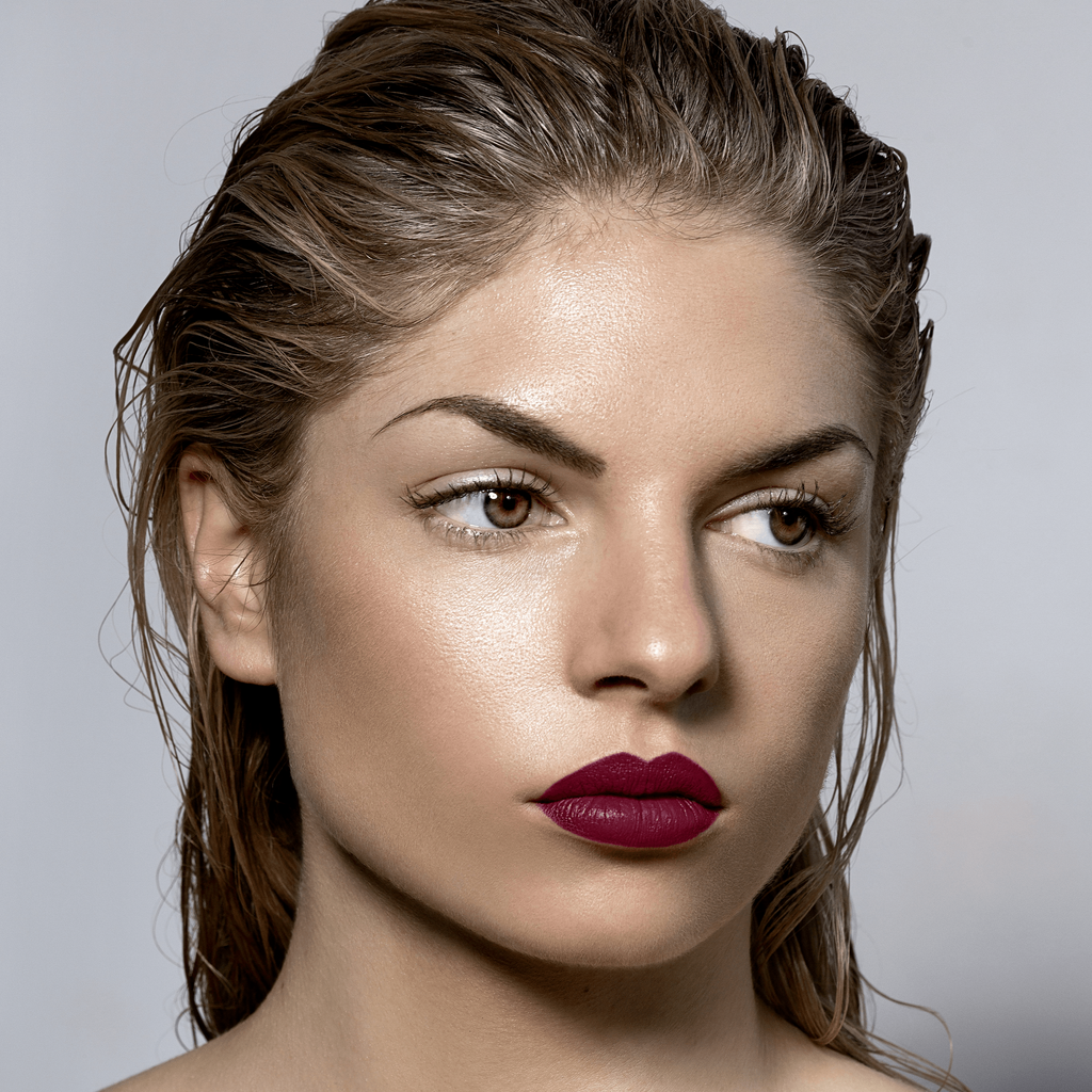 Model wearing Currer dark burgandy red matte lipstick
